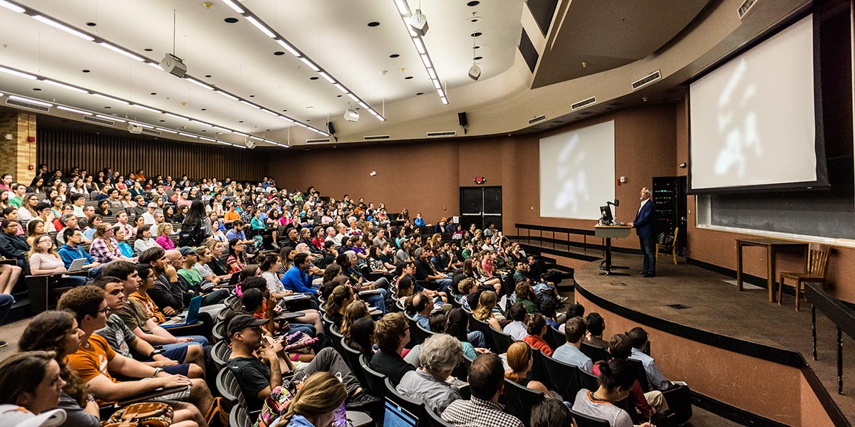 Teacher giving a lesson to a full large lecture hall